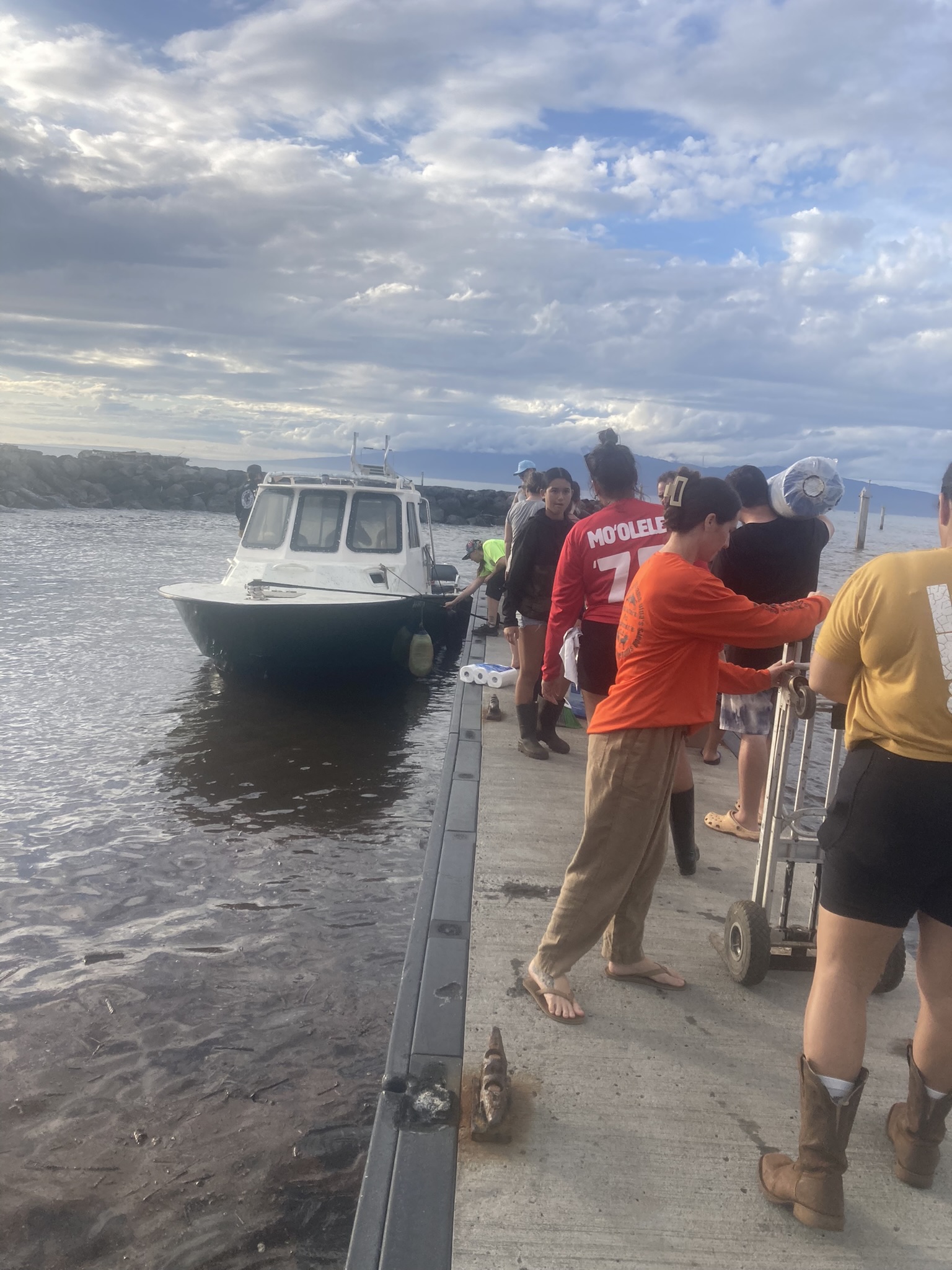 Community volunteers unloading supplies from a boat for Maui recovery.